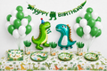 Dinosaurus verjaardagstafel met groene dinoballonnen, Happy Birthday slinger en dinoservies