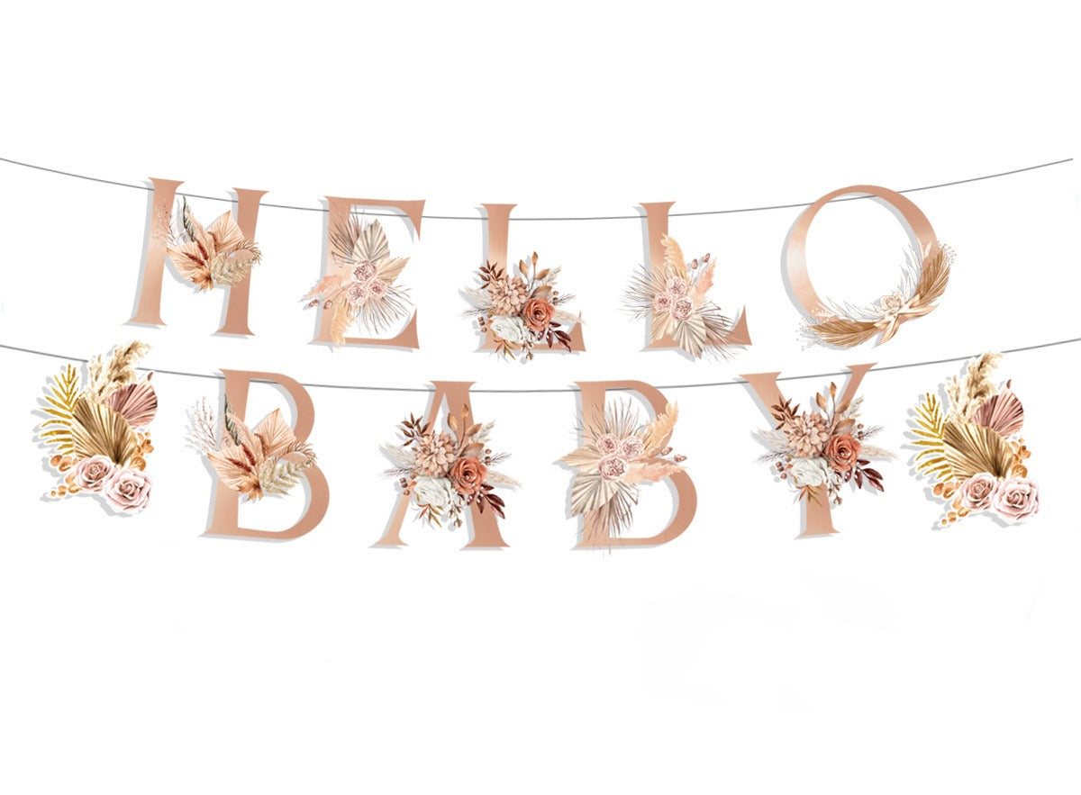 Hello Baby’ letterslinger in twee rijen met roze en beige bloemen en gedroogde bladeren als print.
