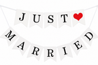 Witte vlaggetjesslinger met zwarte letters Just Married en een rood hart.