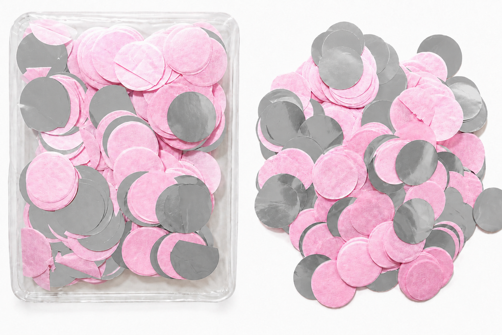 Ronde roze en zilverkleurige confetti in een transparant bakje en los ernaast.
